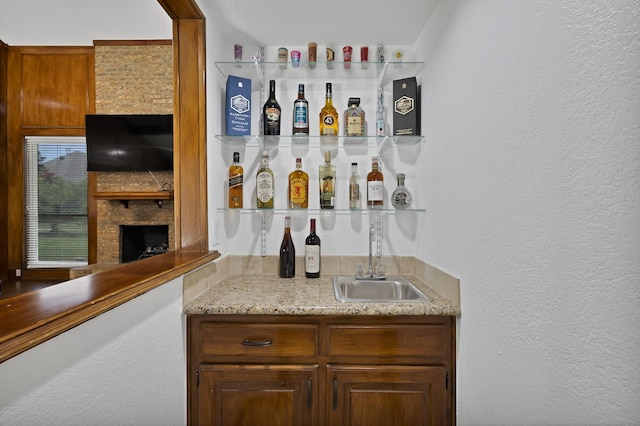 1614 Shadow Moss Way, Carrollton, TX 75007 - indoor wet bar featuring a large fireplace and a textured wall