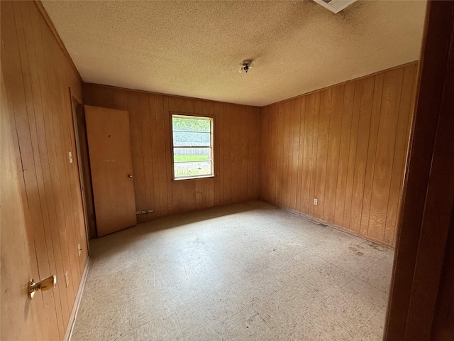 430 Cranford St, Sulphur Springs, TX 75482 - empty room featuring wood walls, tile patterned floors, and a textured ceiling