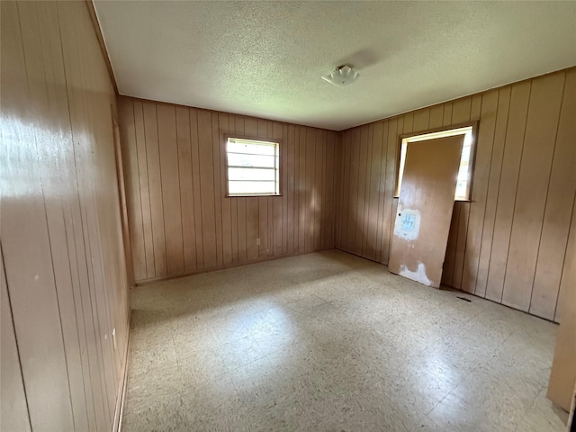 430 Cranford St, Sulphur Springs, TX 75482 - unfurnished room featuring light flooring, wooden walls, and a textured ceiling
