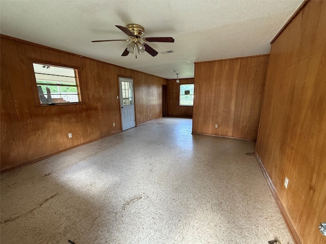 430 Cranford St, Sulphur Springs, TX 75482 - empty room with ceiling fan, wood walls, a textured ceiling, and baseboards