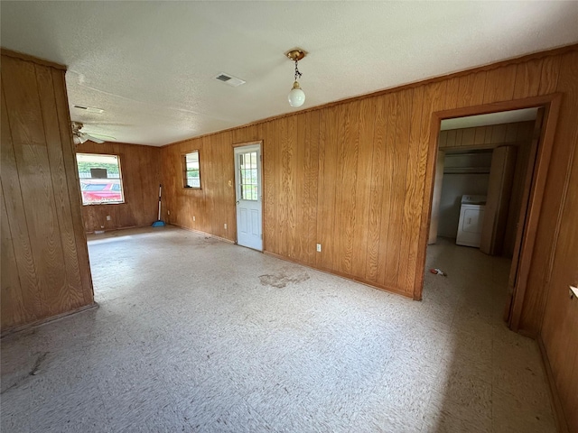 430 Cranford St, Sulphur Springs, TX 75482 - empty room with washer / dryer, wooden walls, a textured ceiling, and baseboards