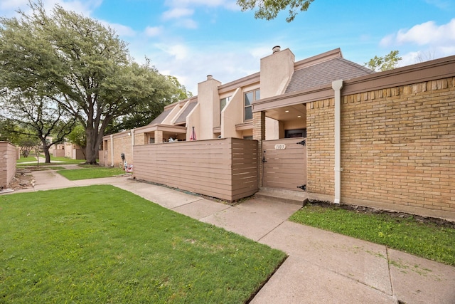 3121 Park Ln Unit 1103, Dallas, TX 75220 - view of home's exterior featuring a gate, a chimney, and brick siding