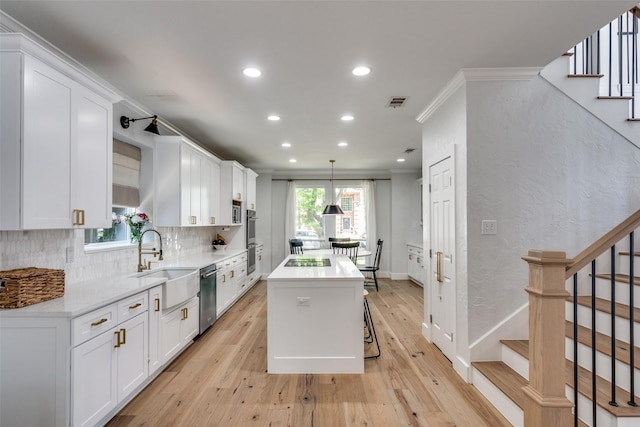 3916 Boulton Ct, Plano, TX 75025 - kitchen with a sink, appliances with stainless steel finishes, a center island, white cabinetry, and recessed lighting