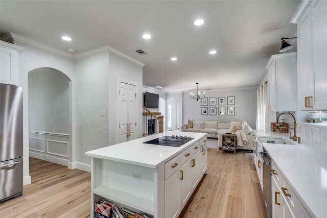 3916 Boulton Ct, Plano, TX 75025 - kitchen with stainless steel appliances, light wood-type flooring, ornamental molding, a sink, and a center island