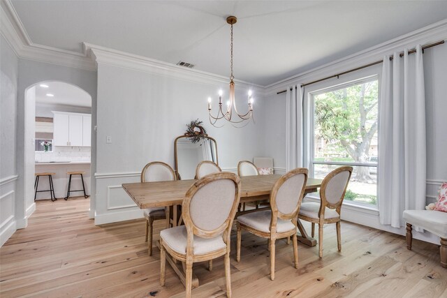 3916 Boulton Ct, Plano, TX 75025 - dining room featuring crown molding, a chandelier, plenty of natural light, arched walkways, and light wood-style flooring