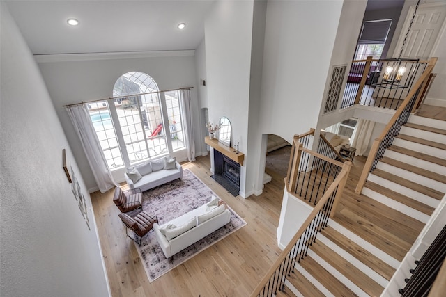 3916 Boulton Ct, Plano, TX 75025 - living area with a chandelier, stairway, ornamental molding, light wood finished floors, and a towering ceiling