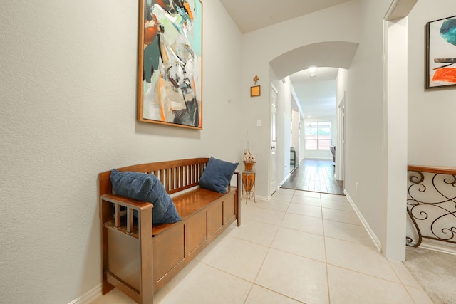 10520 Sexton Dr, Mckinney, TX 75072 - hall featuring arched walkways, light tile patterned floors, and baseboards