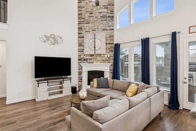 3909 Shrike Trl, Fort Worth, TX 76262 - living area with a towering ceiling, wood finished floors, a large fireplace, and baseboards