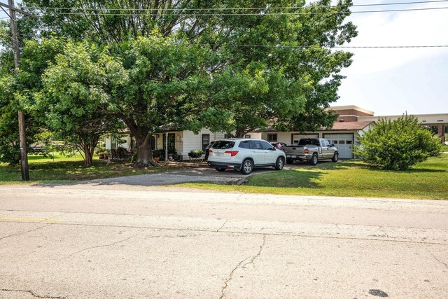 201 S Lake Dallas Dr, Lake Dallas, TX 75065 - view of property hidden behind natural elements with an attached garage, driveway, and a front yard