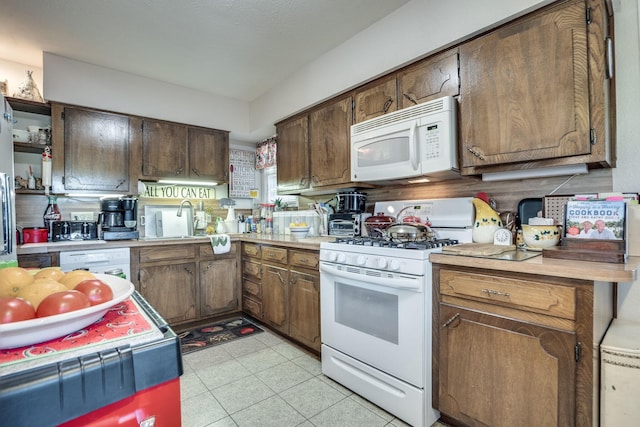 201 S Lake Dallas Dr, Lake Dallas, TX 75065 - kitchen with white appliances, a sink, light countertops, and open shelves