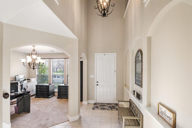 104 Laurel Oak Dr, Red Oak, TX 75154 - entryway with a chandelier, light colored carpet, light tile patterned floors, a high ceiling, and arched walkways