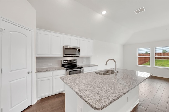 4311 Cordata Dr, Melissa, TX 75454 - kitchen with stainless steel appliances, a sink, vaulted ceiling, dark wood-style floors, and light stone countertops