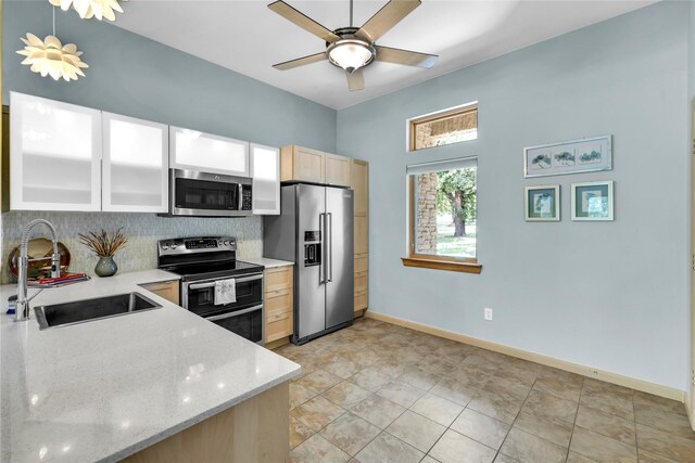 1212 Porter Rd, Bartonville, TX 75022 - kitchen featuring stainless steel appliances, a sink, backsplash, light brown cabinetry, and baseboards