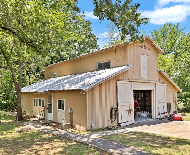 1212 Porter Rd, Bartonville, TX 75022 - rear view of house with a detached garage, an outbuilding, concrete driveway, and metal roof