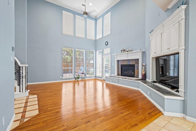 3804 Morning Dove Dr, Plano, TX 75025 - unfurnished living room with a fireplace, stairway, light wood-style flooring, baseboards, and a high ceiling