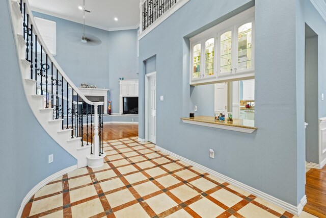 3804 Morning Dove Dr, Plano, TX 75025 - foyer entrance featuring a high ceiling, baseboards, a fireplace with raised hearth, stairs, and inlaid floor details