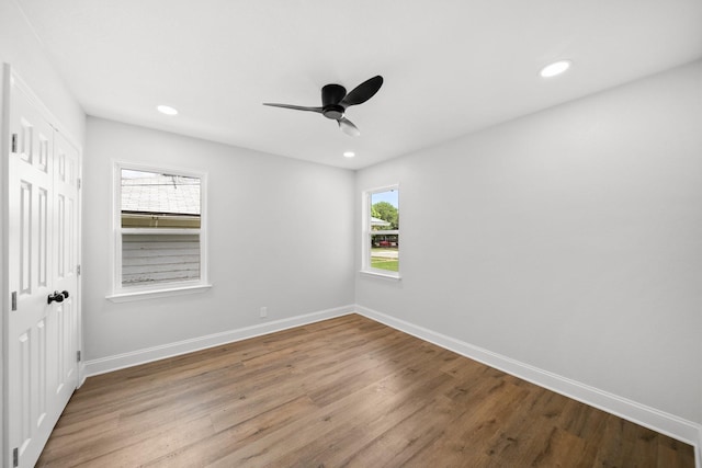 2415 Falls Dr, Dallas, TX 75211 - unfurnished bedroom with multiple windows, wood finished floors, baseboards, and recessed lighting