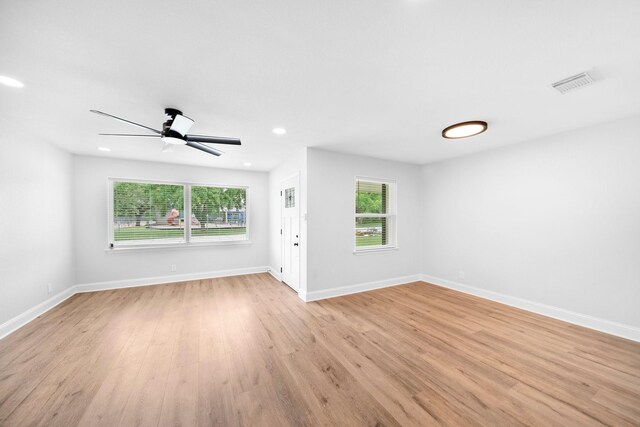2415 Falls Dr, Dallas, TX 75211 - unfurnished living room with plenty of natural light, light wood-style floors, ceiling fan, baseboards, and recessed lighting