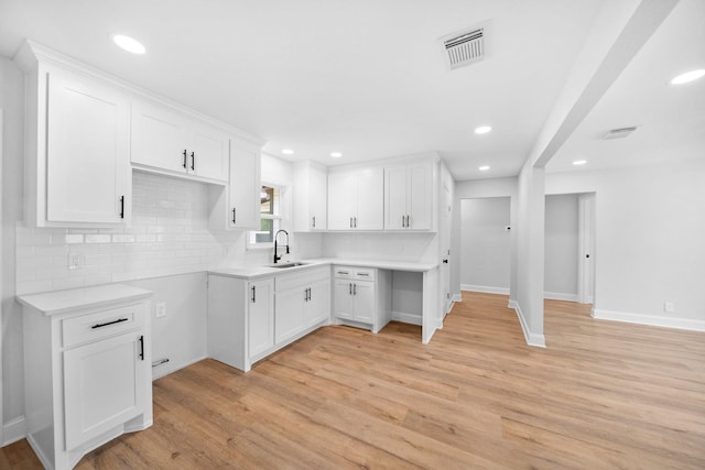 2415 Falls Dr, Dallas, TX 75211 - kitchen with a sink, light wood-type flooring, recessed lighting, baseboards, and white cabinets