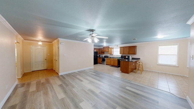 2008 Pine Knot Dr, Heartland, TX 75126 - kitchen featuring stainless steel range with electric stovetop, dark countertops, black fridge with ice dispenser, brown cabinets, and ornamental molding