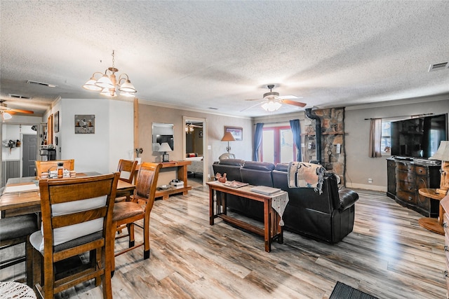1055 Miller Rd, Reno, TX 76020 - living room featuring ceiling fan, a textured ceiling, light wood-style flooring, crown molding, and a chandelier