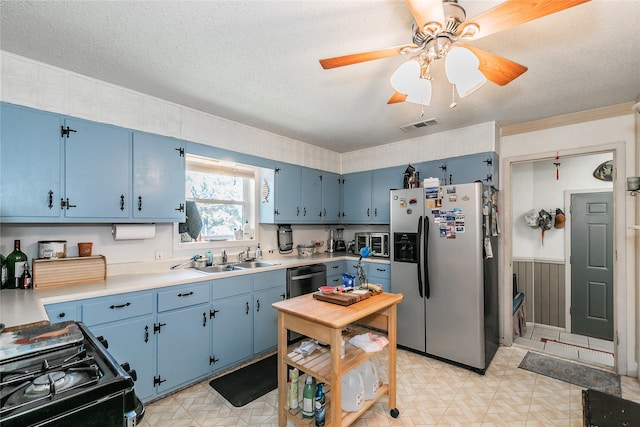 1055 Miller Rd, Reno, TX 76020 - kitchen featuring stainless steel appliances, blue cabinetry, a sink, light countertops, and light floors
