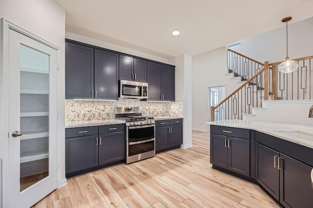 17204 Clover Dr, Celina, TX 75009 - kitchen with stainless steel appliances, a sink, backsplash, light wood-style flooring, and hanging light fixtures