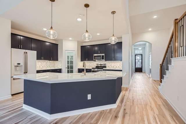 17204 Clover Dr, Celina, TX 75009 - kitchen with stainless steel appliances, a sink, arched walkways, backsplash, and recessed lighting