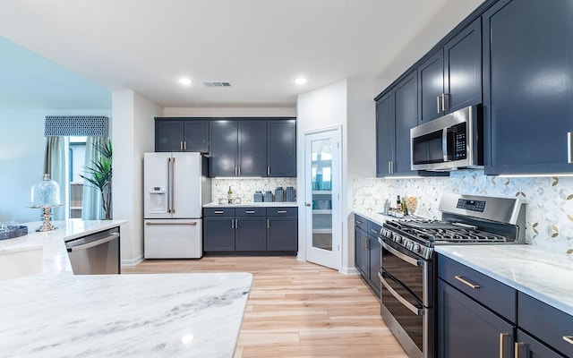 17204 Clover Dr, Celina, TX 75009 - kitchen with stainless steel appliances, light wood-style flooring, tasteful backsplash, light stone countertops, and recessed lighting