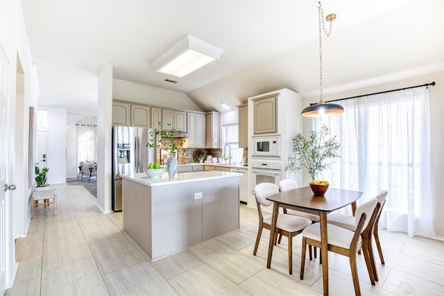 11471 Balcones Dr, Frisco, TX 75033 - kitchen with white appliances, a kitchen island, light countertops, vaulted ceiling, and a sink
