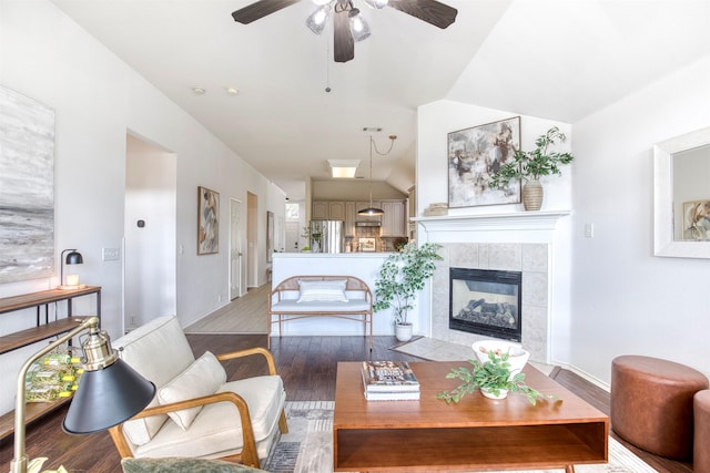 11471 Balcones Dr, Frisco, TX 75033 - living room featuring ceiling fan, wood finished floors, vaulted ceiling, and a tile fireplace