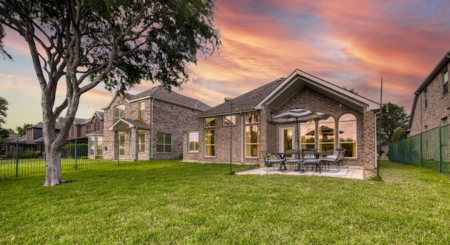 11471 Balcones Dr, Frisco, TX 75033 - back of property at dusk with brick siding and a patio area