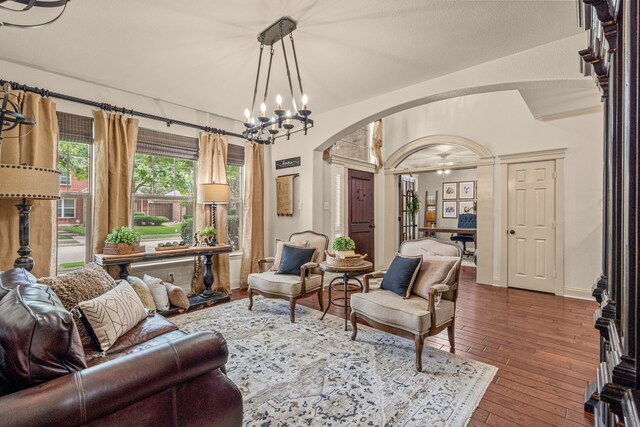 1702 Clarke Springs Dr, Allen, TX 75002 - living room featuring arched walkways, dark wood-style flooring, a chandelier, and baseboards