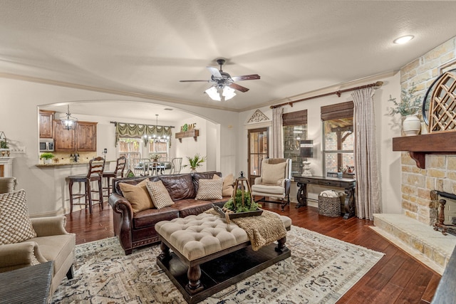 1702 Clarke Springs Dr, Allen, TX 75002 - living room featuring arched walkways, a ceiling fan, wood-type flooring, a textured ceiling, and a chandelier