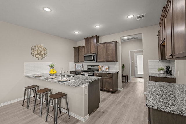 1601 Bennington Ln, Celina, TX 75009 - kitchen featuring stainless steel appliances, a sink, tasteful backsplash, light stone counters, and recessed lighting