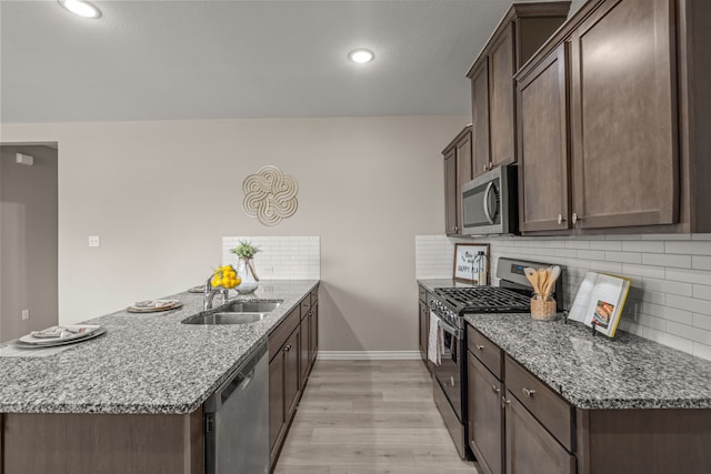 1601 Bennington Ln, Celina, TX 75009 - kitchen with stainless steel appliances, a peninsula, dark brown cabinets, decorative backsplash, and recessed lighting