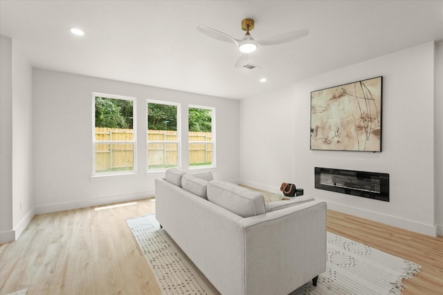 1344 Compton St, Dallas, TX 75203 - living area with light wood-style floors, ceiling fan, baseboards, a glass covered fireplace, and recessed lighting