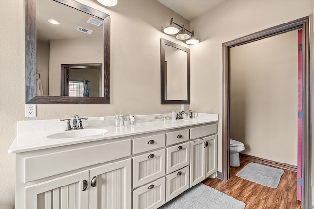 4905 Lakepark Dr, Sanger, TX 76266 - bathroom with double vanity, toilet, wood finished floors, and baseboards