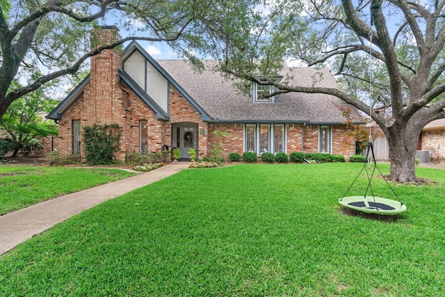 10007 Silver Creek Rd, Dallas, TX 75243 - tudor home with brick siding, a front yard, a chimney, and a shingled roof