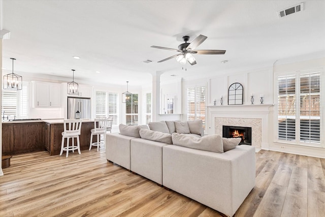 4804 Arbor Glen Dr, Mckinney, TX 75072 - living area featuring light wood finished floors, recessed lighting, a premium fireplace, a ceiling fan, and crown molding