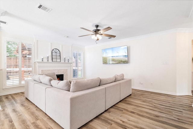 4804 Arbor Glen Dr, Mckinney, TX 75072 - living room featuring light wood-type flooring, a premium fireplace, a ceiling fan, healthy amount of natural light, and crown molding