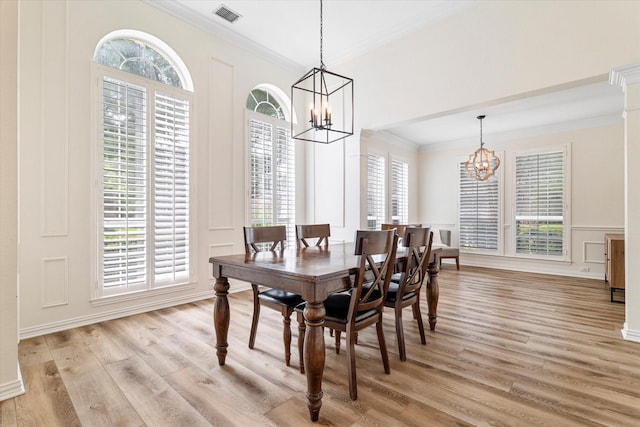 4804 Arbor Glen Dr, Mckinney, TX 75072 - dining room featuring a chandelier, ornamental molding, a decorative wall, light wood-style flooring, and wainscoting
