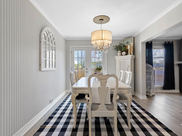 910 N Mill St, Bowie, TX 76230 - dining area featuring healthy amount of natural light, a chandelier, french doors, wood finished floors, and ornamental molding