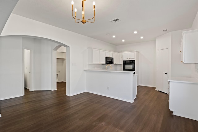 1111 Devonshire Dr, Glenn Heights, TX 75154 - kitchen featuring dark wood-style flooring, arched walkways, white cabinets, backsplash, and recessed lighting