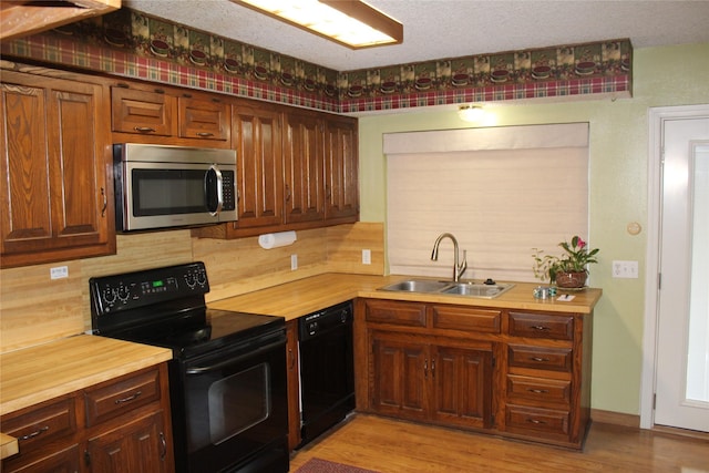 1424 Valley Trl, Mesquite, TX 75149 - kitchen with black appliances, a sink, decorative backsplash, light wood-style floors, and wooden counters