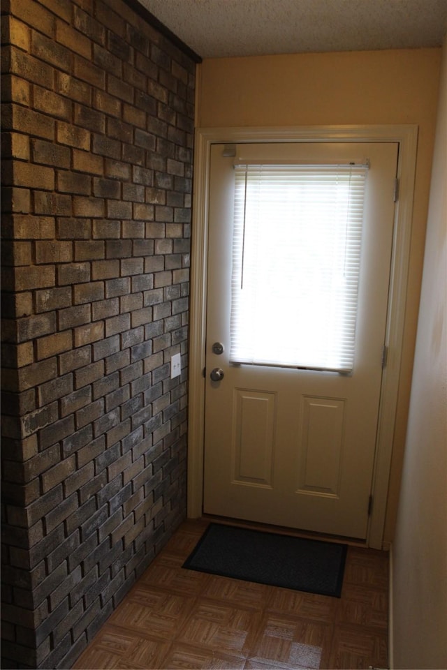 1424 Valley Trl, Mesquite, TX 75149 - doorway to outside featuring a textured ceiling and brick wall