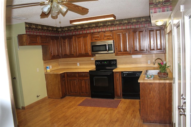 1424 Valley Trl, Mesquite, TX 75149 - kitchen with black appliances, light countertops, a textured ceiling, a ceiling fan, and light wood-type flooring