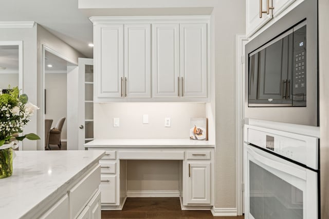 726 Nettleton Dr, Southlake, TX 76092 - kitchen featuring oven, stainless steel microwave, dark wood finished floors, white cabinets, and crown molding