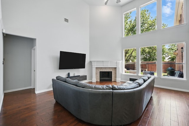 14877 Snowshill Dr, Frisco, TX 75035 - living room with a high ceiling, dark wood-type flooring, a fireplace, baseboards, and healthy amount of natural light