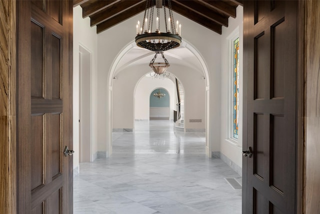 4400 Belfort Pl, Highland Park, TX 75205 - hallway featuring a chandelier, arched walkways, light marble finish floors, and baseboards